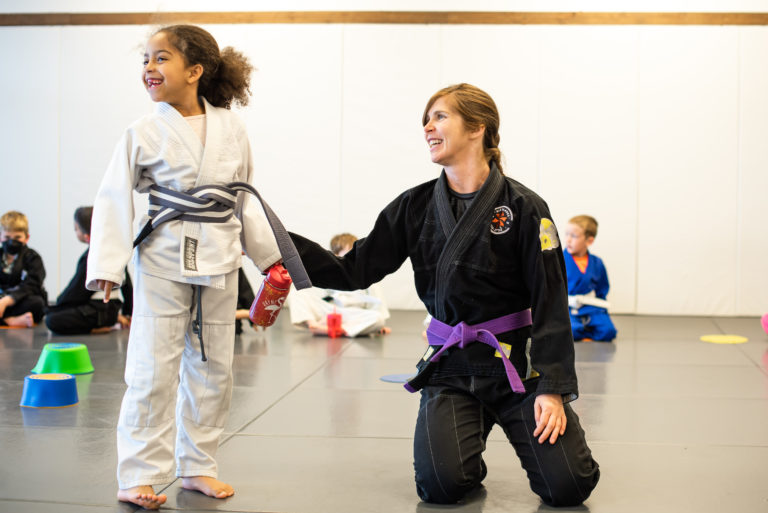 Coach Hannah belt promotion with 6 year old girl in martial arts Broomfield